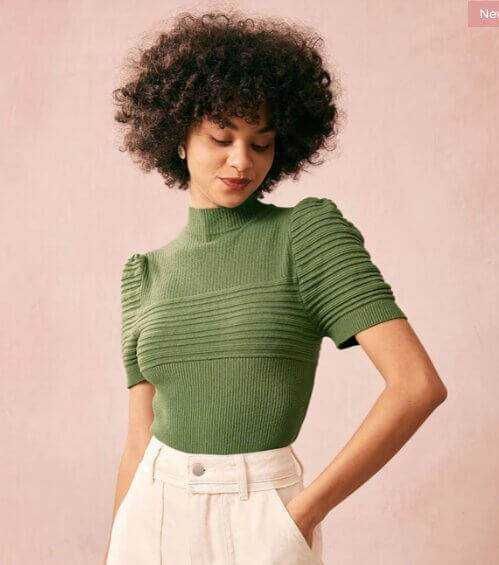 Modella con maglia verde a maniche corte e spalle arricciate, eleganti dettagli di moda, stile femminile, abbigliamento donna, outfit di tendenza, fashion primavera estate.