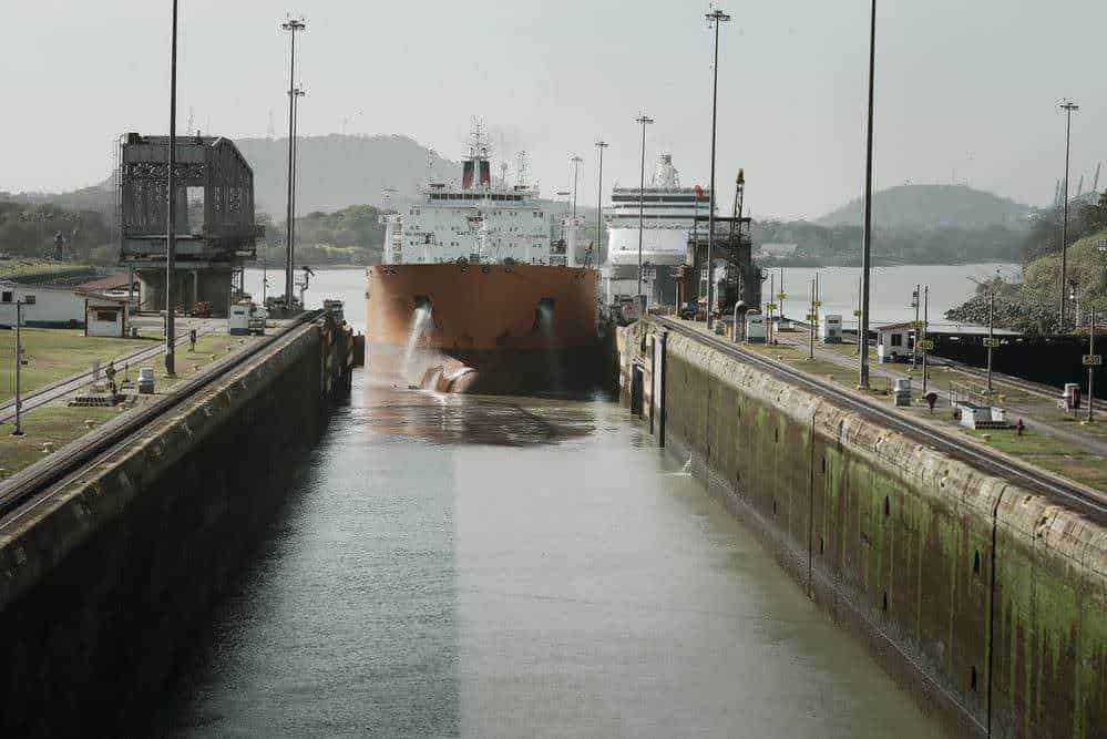 Nave da crociera nel canale di accesso ai dock portuali, ambientazione marittima, operazioni di navigazione, attività portuali, porto commerciale, scenario marittimo, trasporto merci via mare, ingranaggi industriali navali, immagine di logistica e trasporto, ambientazioni industriali marittime.