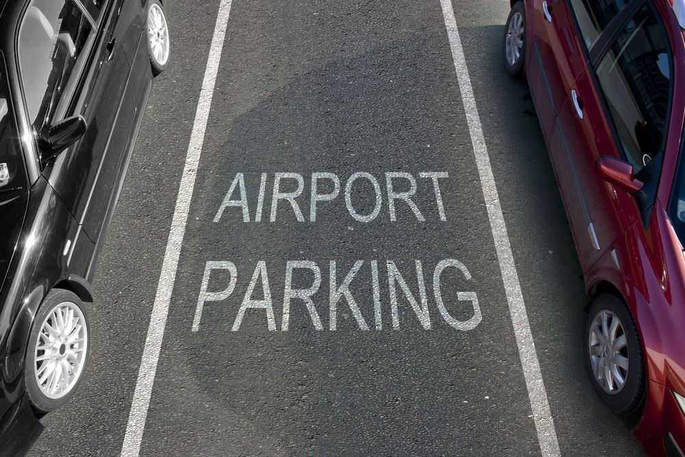 Auto in parcheggio dedicato all'aeroporto, spiacevole parcheggio in zona riservata. Parcheggi auto di varie tipologie e colori in un'area dedicata con segnaletica chiara.
