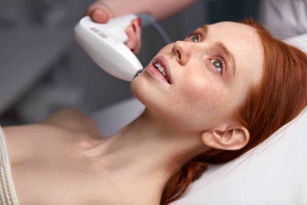 Ragazza con pelle acneica sottoposta a trattamento dermatologico usando ultrasuoni, cura della pelle e medicina estetica, trattamento viso.