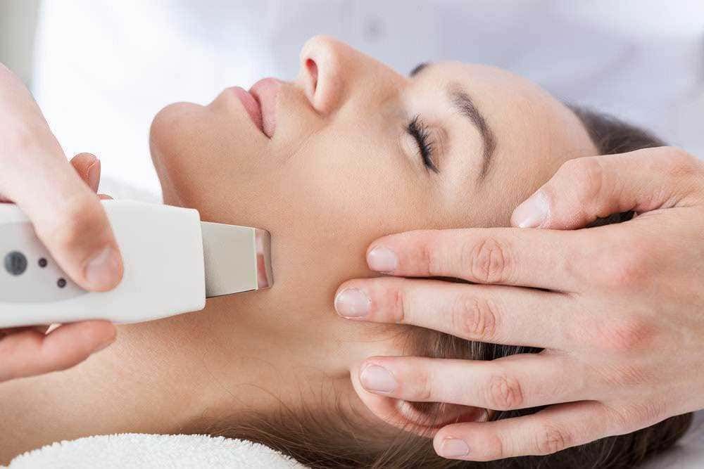 Trattamento estetico viso con apparecchio laser per la cura della pelle e il ringiovanimento cutaneo. Tecnica avanzata di estetica per migliorare la tonicità e la luminosità della pelle del viso.