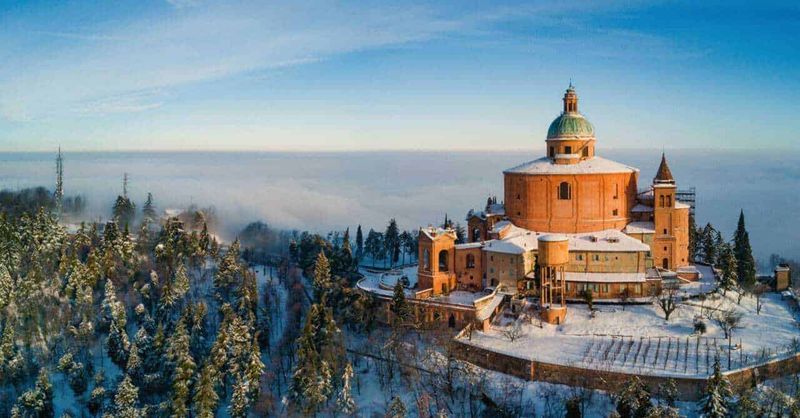 Domenica delle Palme 2023: Esperienza unica nel Nord Italia 7 Castello di neve in inverno con paesaggio montano e cielo azzurro, vista panoramica sulla natura e sull'architettura storica, atmosfera tranquilla e suggestiva, destinazione ideale per fotografie e viaggi.