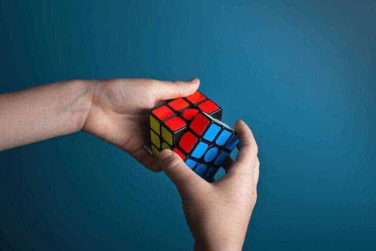 Rubik's Cube in mano, risoluzione problema con metodo strategico, quiz mentale, gioco di logica.