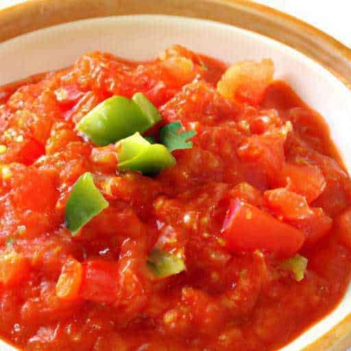 Passata di pomodoro fresca con pezzetti di pomodoro e ciuffetti di prezzemolo in una ciotola di ceramica.