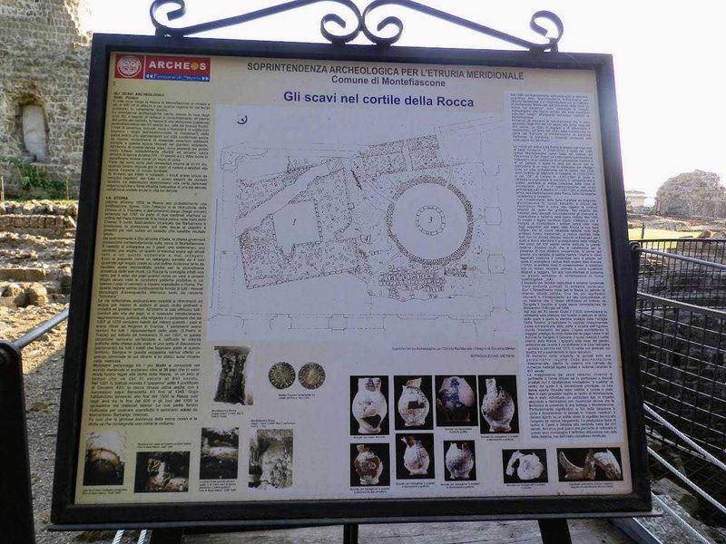 11 Borghi e luoghi da visitare nel Lazio Nord-Ovest 8 Restauro di un sito archeologico con pannello informativo sulle scoperte e i reperti rinvenuti nel cortile della Rocca a Montefiascone. L'area archeologica mostra frammenti di strutture antiche e ceramiche.