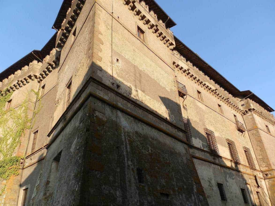 Vecchio castello medievale in pietra con torrette e merlature, esempio di architettura storica italiana, fotografato sotto un cielo limpido.