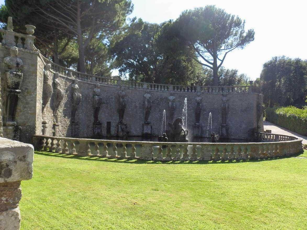 Fontana storica con sculture, gazebo e fontane in giardino verde, large trees, pareti in pietra, illuminazione naturale, atmosfera tranquilla, luoghi di relax e bellezza naturale, decorazioni eleganti, ambiente all'aperto panoramico, punti di interesse storico e artistico.