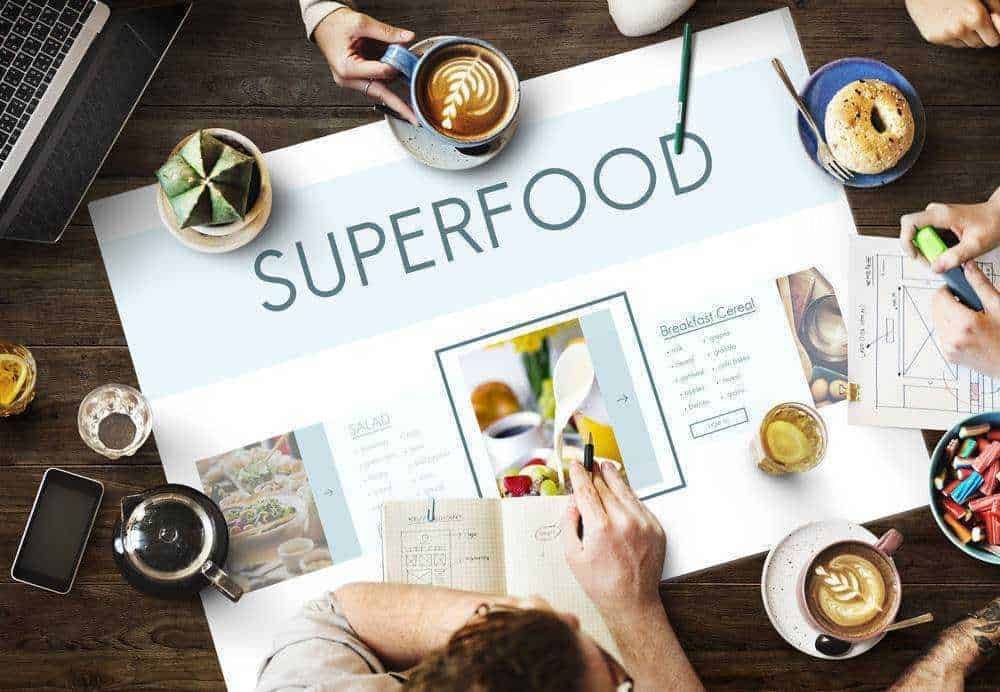 7 alimenti nutrienti: Supercibi nutrienti: Superfood, alimenti salutari e ricette innovative per uno stile di vita sano e bilanciato. Immagine di una riunione di lavoro con snack e bevande salutari su un tavolo di legno.