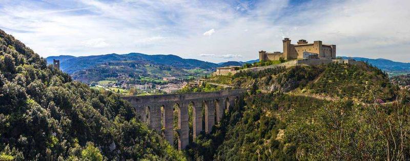 10 Città turistiche in Umbria da visitare, tra chiese romaniche 7 Castello e viadotto in una valle verde, paesaggio naturale con fiumi e montagne, vista panoramica panoramica dell'antica fortezza e ponte storico in Italia.