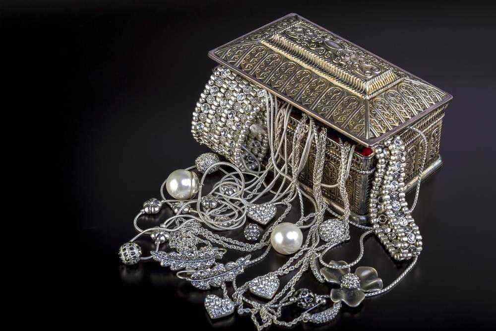 Bracciali, collane e orecchini in argento e perle di lusso, sparsi su un cofano bijoux ornato di dettagli ricamati ed eleganti, ambientati su uno sfondo nero di alta moda e gioielli di prestigio.