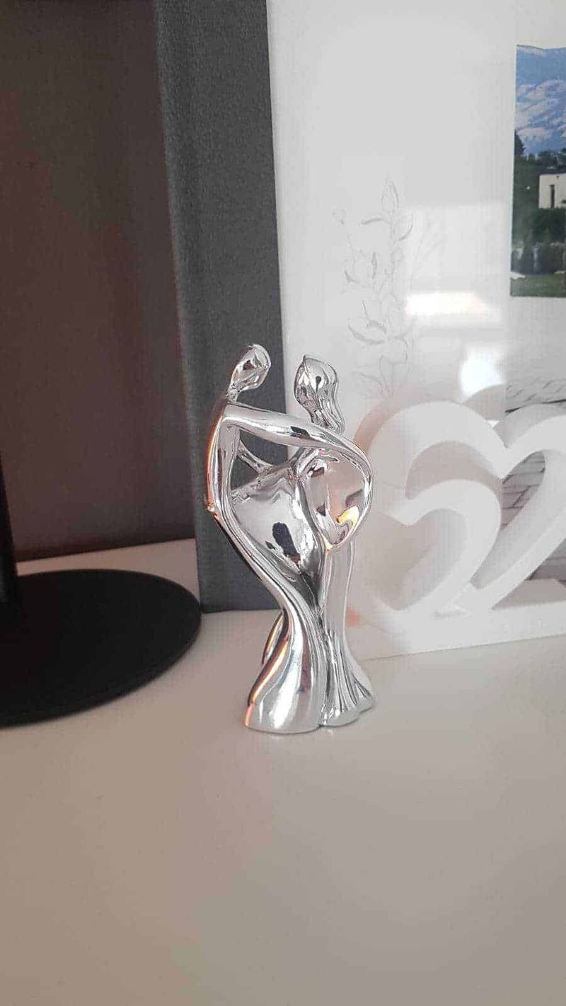 Come Riconoscere l'Argento Vero: 10 Tipi, Punzoni e 7 Test Infallibili 6 Elegante statua femminile in metallo lucido, decorazione moderna per ambienti living, riflessi di luce sulla superficie cromata.