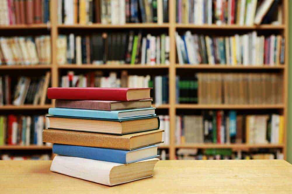 Pile di libri colorati su tavolo in libreria, simbolo di lettura e cultura, rappresentano la passione per la conoscenza e l'apprendimento continuo. Perfetto per siti di libri, biblioteche e studi letterari.