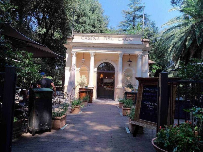 15 Parchi a Roma dove rilassarsi 7 Cassina del Lago, ingresso affascinante con colonne e luci, ristorante immerso nel verde, perfetto per cene eleganti e relax, atmosfera rilassante in un luogo pittoresco.