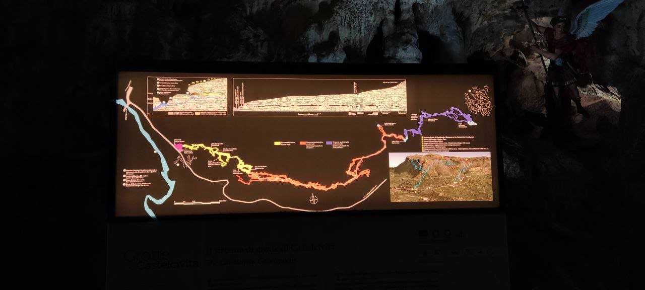 Percorso sotterraneo con mappa interattiva delle grotte, dettagli sui percorsi e caratteristiche geologiche, in un'ambientazione naturalistica.