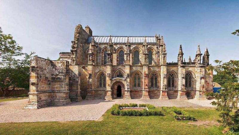 I Cavalieri Templari storia 10 fatti mitici 4 Antica chiesa gotica in pietra, esempio di architettura storica e religiosa, immersa in un parco verde con un cielo sereno. Perfetta per appunti su storia e arte medievale.