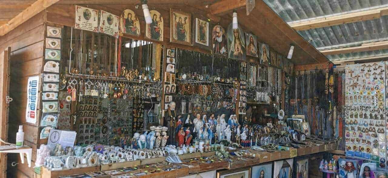 Scarico di souvenir artigianali e oggetti religiosi in un mercatino di montagna, con statue, ornamenti e creazioni in legno e ceramica. Articoli unici perfetti per ricordi e regali spirituali.