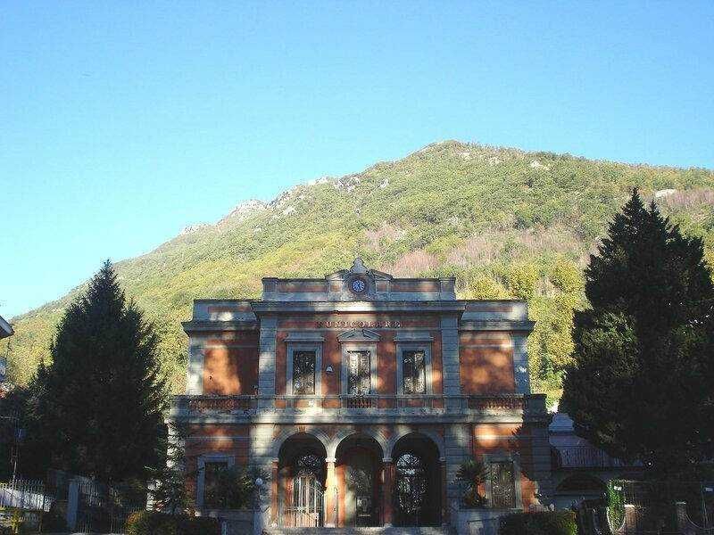 Montevergine santuario femminielli Avellino 13 Antica stazione ferroviaria in stile classico con archi e dettagli in pietra, immersa nel contesto naturale delle montagne verdi e alberi carreggiati, in un paesaggio di tranquillità e storia.
