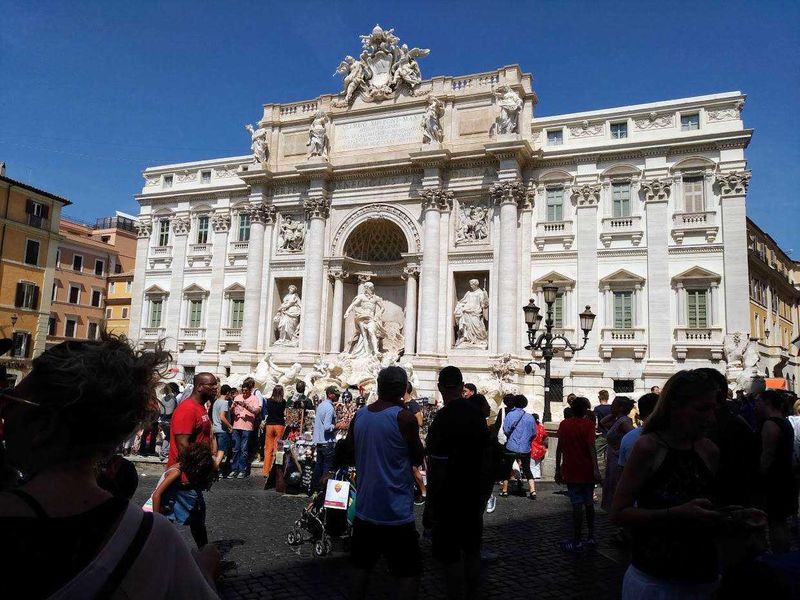 Perché è famosa la Fontana di Trevi? 10 Arcata di Fontana di Trevi Roma, monumento iconico di Roma, fontana barocca famosa, piazza turistica Roma, attrazione turistica Roma, sculture in pietra, fontane storiche di Roma, turismo a Roma, piazza con fontana antica, monumento storico italiano.