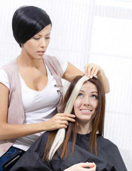 Capelli da colorare, parrucchiere professionista applica tintura sui capelli della cliente, servizio di colorazione e trattamenti capillari, stylist visita salone di bellezza, cura dei capelli.