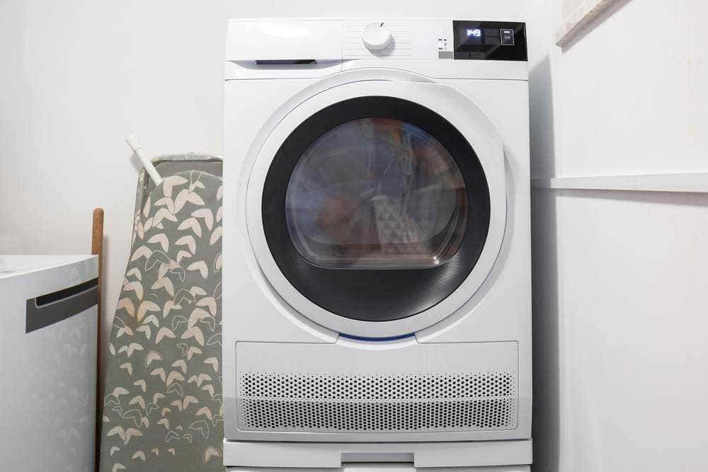 Lavatrice moderna bianca in un lavatoio domestico, spazio pulito e ordinato ideale per la cura dei vestiti e il bucato quotidiano, perfetta per ambienti di casa funzionali e ben organizzati.