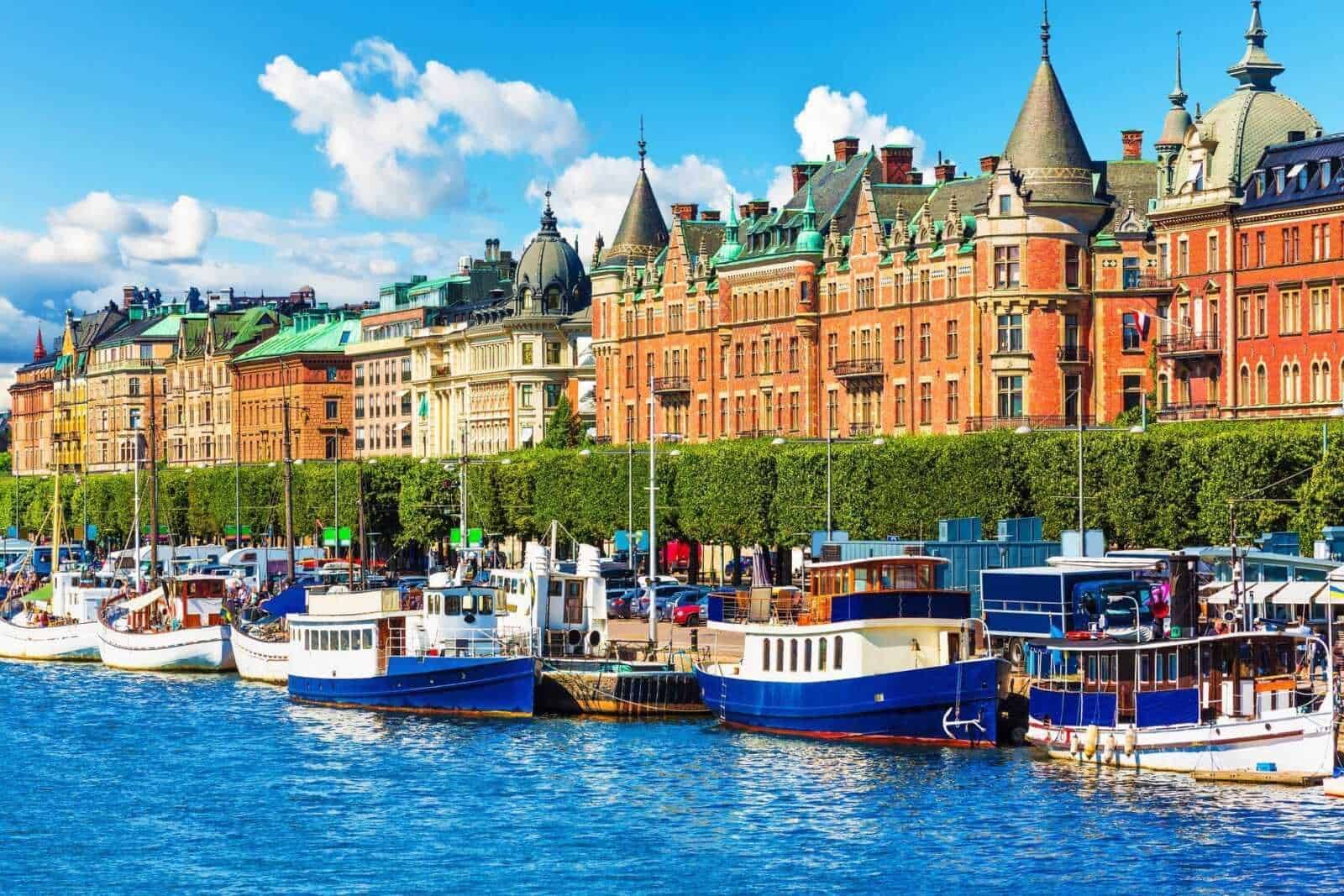 Barche nel porto di Stoccolma con edifici storici sullo sfondo, vista sul mare svedese, immagine di un porto turistico svedese, architettura urbana di Stoccolma, città nordica e turismo marittimo.