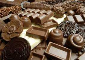 Delizie di cioccolato e frutta fresca in ciotole di ceramica, perfette per una colazione o dessert goloso, accompagnate da panna montata e biscotti. Locale accogliente per momenti conviviali.
