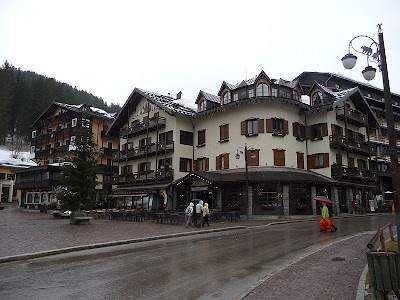 Dormire in un Hotel a Madonna di Campiglio tra neve perenne e laghi azzurri 5 Belle vista delle montagne innevate e di un piccolo villaggio alpino immerso tra i pini in una località sciistica italiana. Perfetta per articoli su turismo invernale e vacanze in montagna.