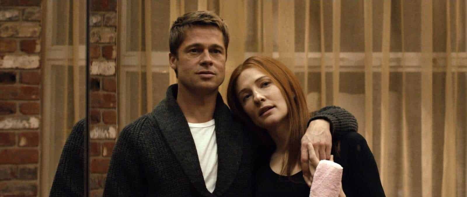 Sposato con due personaggi principali, uomo con capelli castani e donna con capelli rossi, in un'ambientazione con pareti in mattoni e tende di fronte.