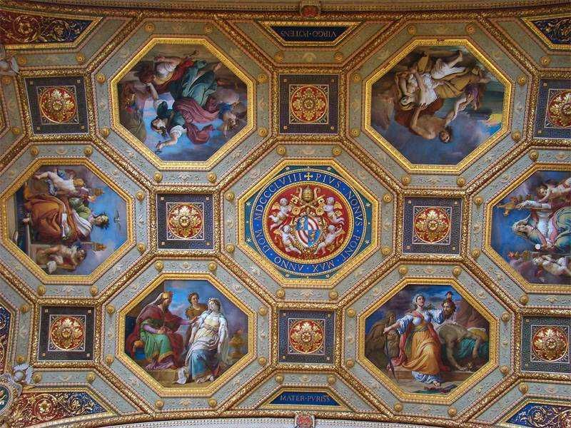 Dettaglio di un soffitto decorato con affreschi religiosi e motivi dorati, tipico dell’arte barocca, situato in una chiesa storica o un palazzo rinascimentale.