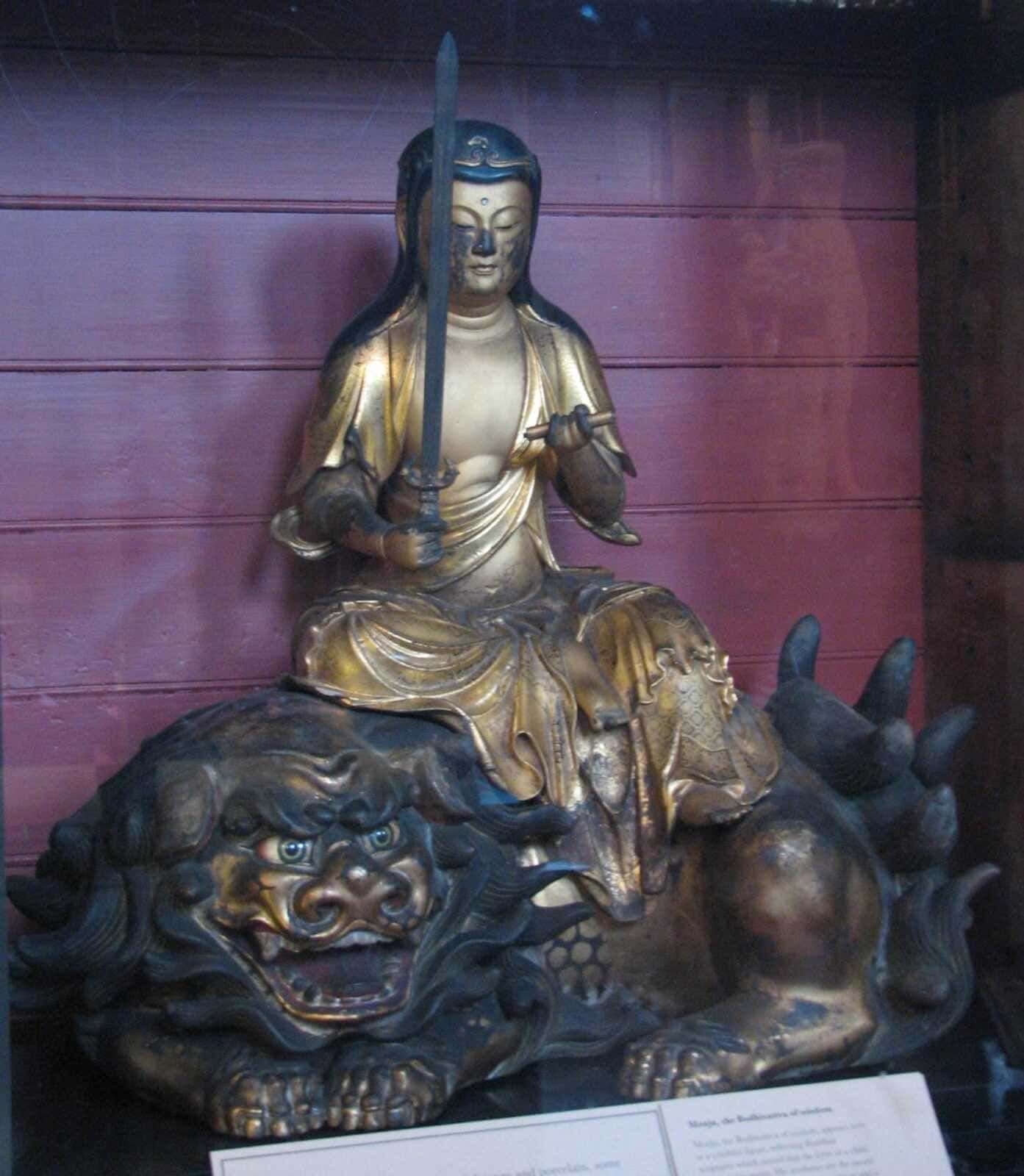 Futuro, statua di un guerriero orientale in metallo oro e argento con spada e scudo, seduto su un leone di metallo scuro, in una mostra culturale.