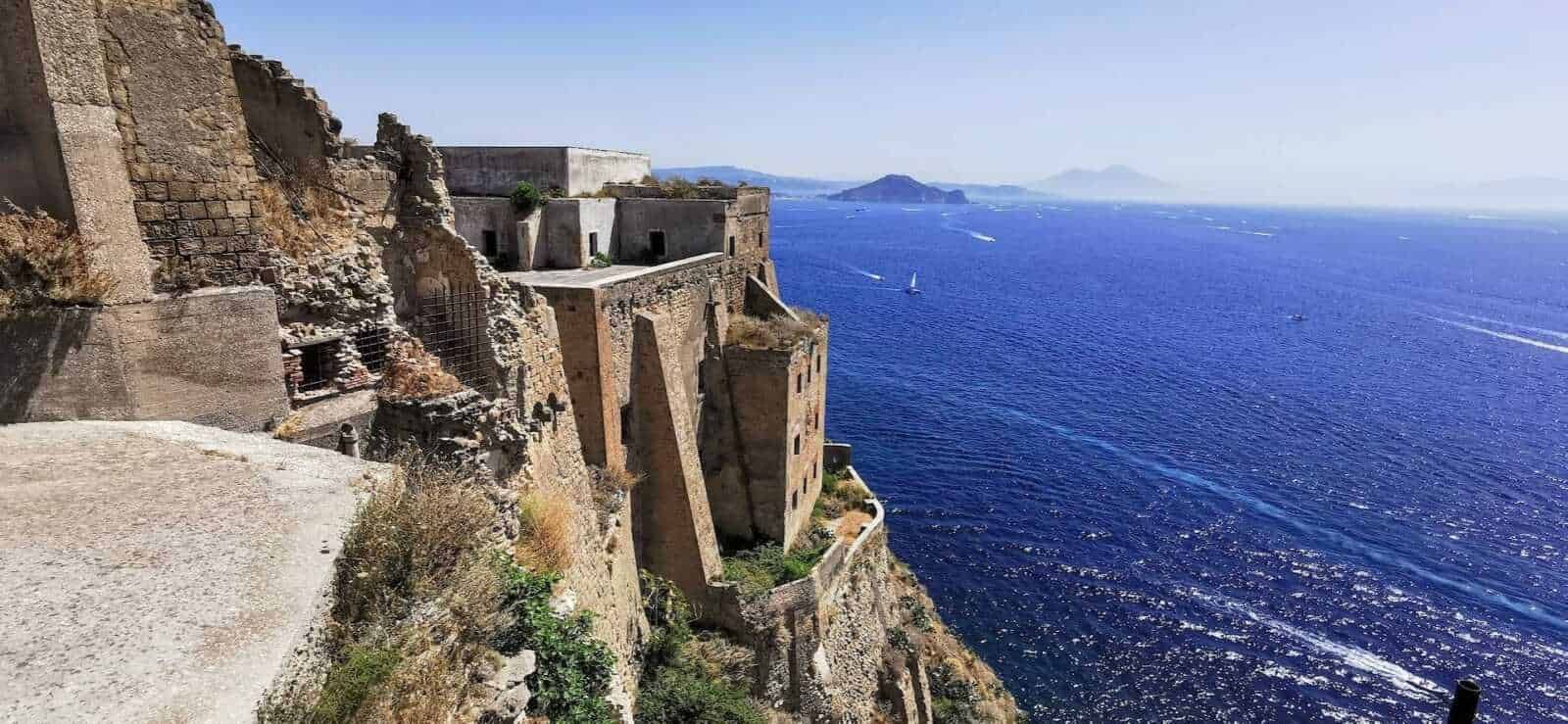 Antico castello sulla scogliera con vista sul mare cristallino e sulle isole vicine in Italia. Paesaggio mozzafiato con architetture storiche e acque turchesi, ideale per appassionati di storia e viaggi estivi.