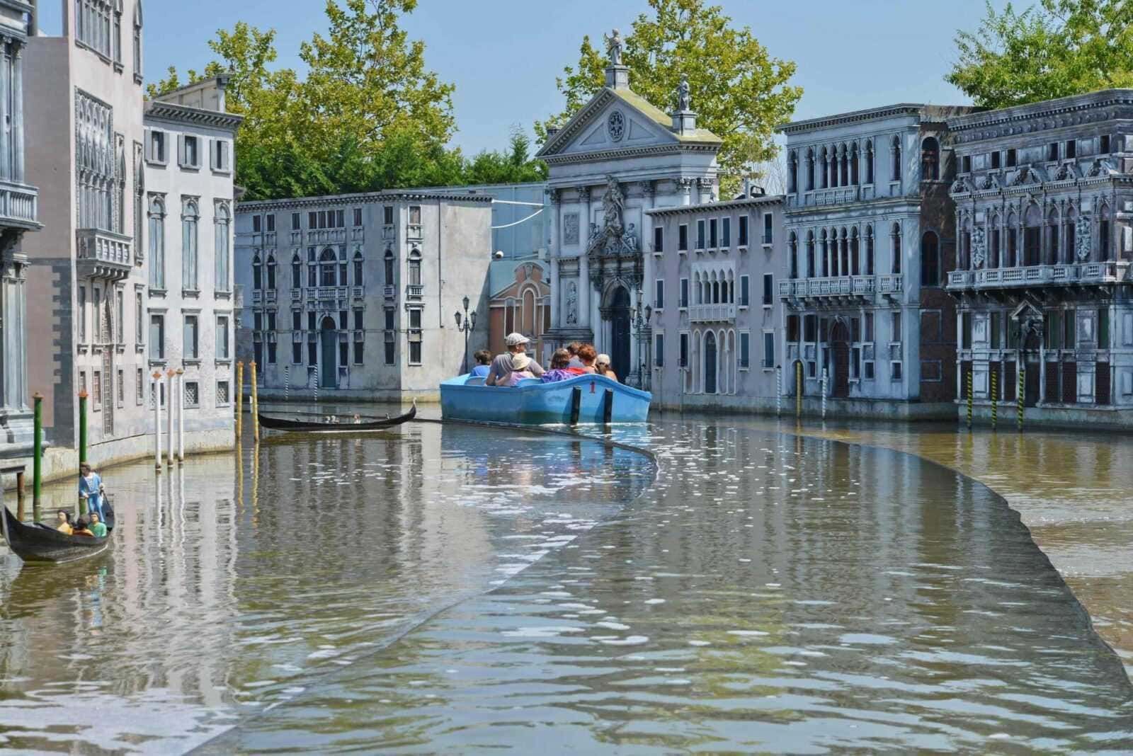 Passeggeri che navigano sulla gondola a Venezia, in un'area con edifici storici e canali, scena pittoresca e turistica in Italia, perfetta per scatti di viaggio e cultura veneziana.