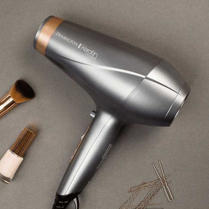Lieve Remington Keratin Protect asciugacapelli con accessori per styling e trucco su sfondo grigio.