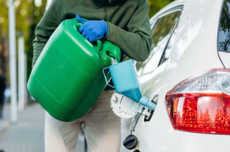 Serbatoio benzina auto in riserva, 6 consigli guida sicura 4 Container verde per prodotti chimici e attrezzi di pulizia, utilizzo durante il rifornimento di prodotti per la cura dell'auto, attenzione alla sicurezza e all'ambiente, immagini di manutenzione auto, eco-sostenibilità.