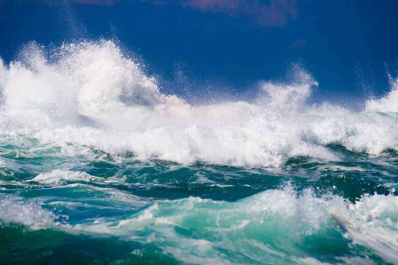 Oceano Pacifico perché si chiama così? 4 teorie 3 Ondata di onde oceaniche sotto un cielo azzurro, ideale per blog su natura, mare e avventure acquatiche.