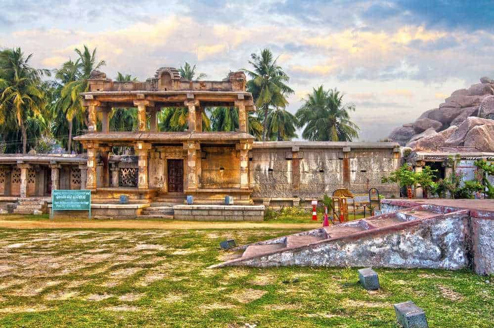 Antica struttura in pietra con ambientazione tropicale, palme e rocce, testimonianza storica su Appunti Sul Blog, perfetta per esplorare il patrimonio culturale e architettonico dell'India.