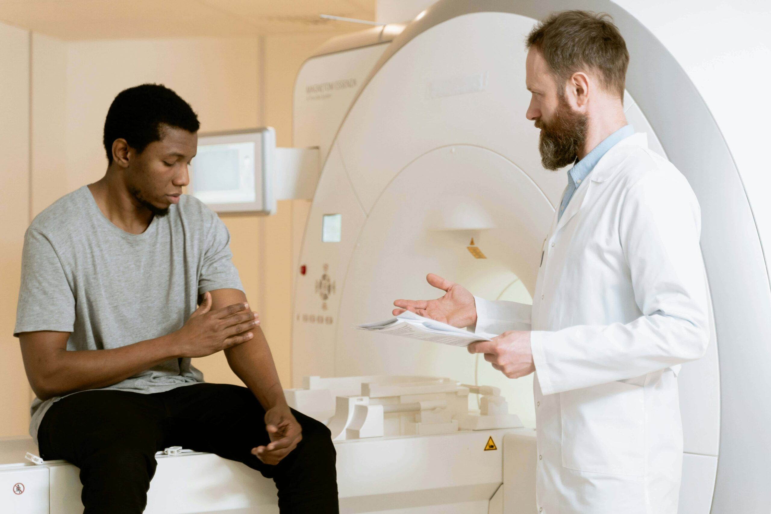 Imaging scans, consulente medico e paziente in ambulatorio. Qualità delle immagini sanitarie e diagnosi. Immagine di un medico e un giovane paziente durante una visita medica in clinica radiologica.