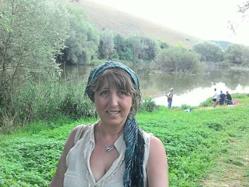 Esplorando il Fascino del Paesaggio di Montagna 3 Vita all'aperto sul fiume, donna con sciarpa blu e camicia bianca, paesaggi naturali, incontri tra amici, relax nella natura, attività di pesca, ambiente tranquillo, scenari verdi e serene, escursione all'aperto, ritratto di donna felice.