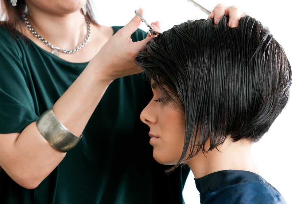 Taglio di capelli moderno e stile elegante, parrucchiere professionista che lavora su una cliente con capelli corti e lisci, trattamento di styling in salone di bellezza.