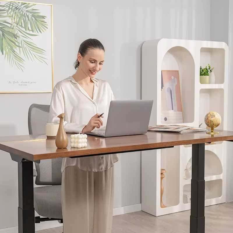 Schermata di donna sorridente mentre lavora al computer in un ambiente elegante e minimalista con decorazioni moderne e piante verde chiaro.