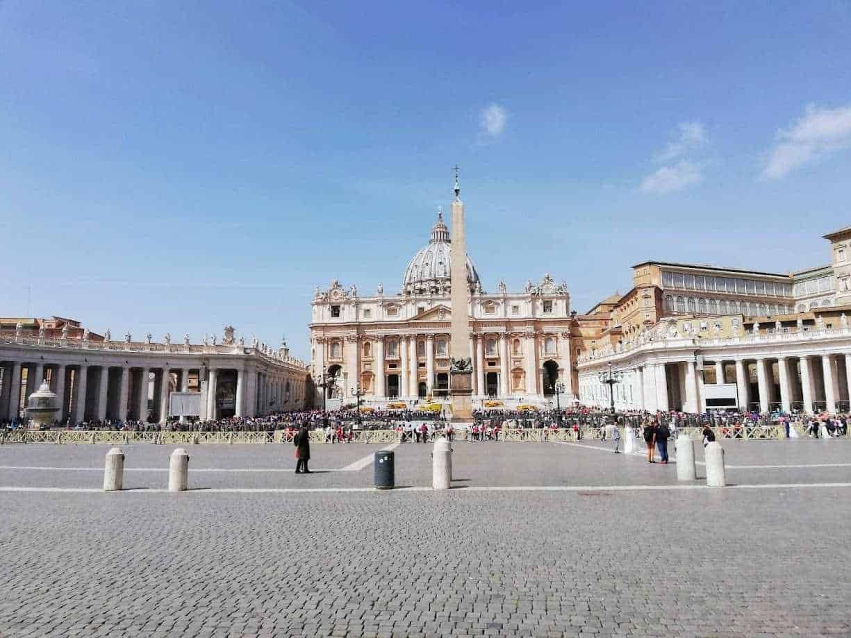 Immagine della Basilica di San Pietro in Vaticano, con piazza affollata e cielo sereno sullo sfondo, rappresentazione iconica di Roma e meta turistica principale.