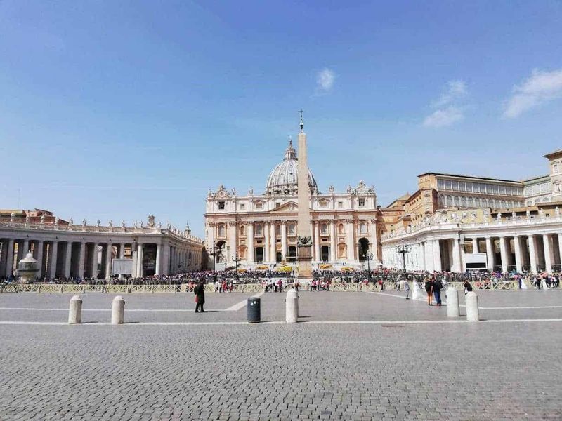 7 Cose da vedere in Piazza San Pietro gratis 5 Immagine della Basilica di San Pietro in Vaticano, con piazza affollata e cielo sereno sullo sfondo, rappresentazione iconica di Roma e meta turistica principale.