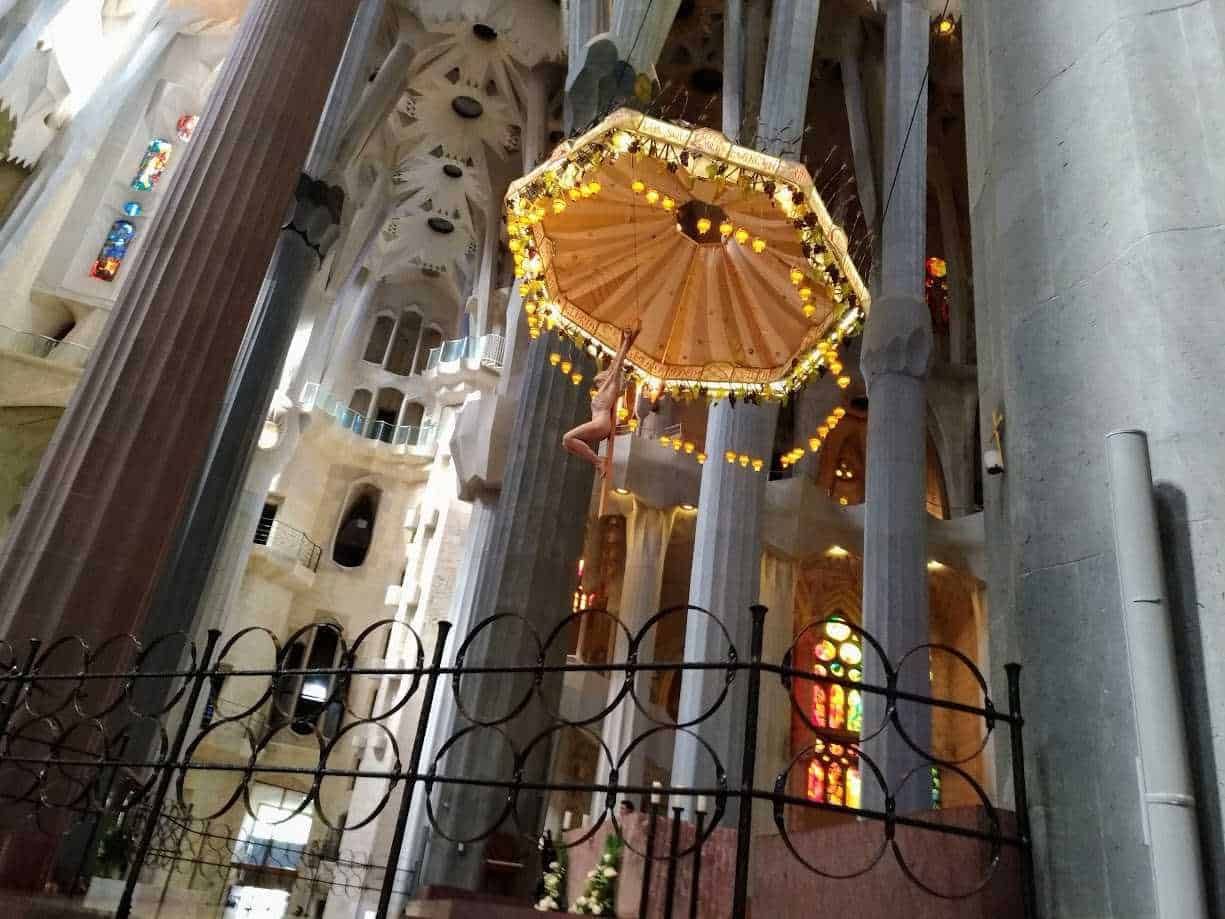 Lampadario decorativo all'interno della basilica di Sagrada Família, con illuminazione calda e dettagli artistici, simbolo di architettura innovativa e arte sacra a Barcellona.