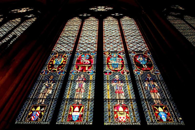 Cos'è il gotico, arte gotica dal classico al moderno 7 Colorato vetro artistico con figure storiche e simboli religiosi, originale decorazione di una grande finestra in una chiesa gotica, creata con tecnica di vetrata colorata.
