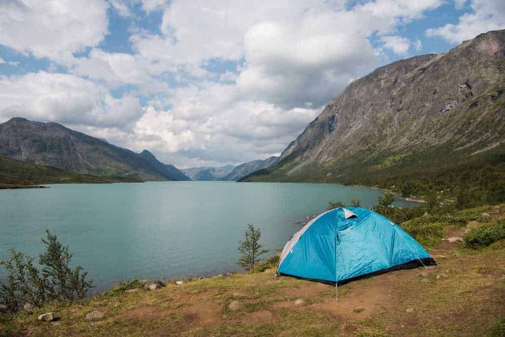 Tenda da campeggio nel paesaggio naturale con lago e montagne, perfetta per avventure all'aperto e campeggio nel wilderness, ideale per escursioni e camping in natura.