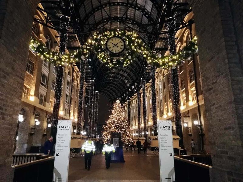 10 Quartieri di Londra a capodanno 2 Quartieri da scoprire: Decorazioni natalizie all'interno di un centro commerciale con albero di Natale illuminato, ghirlande festive e luci scintillanti, creando un'atmosfera magica e accogliente durante il periodo delle feste.