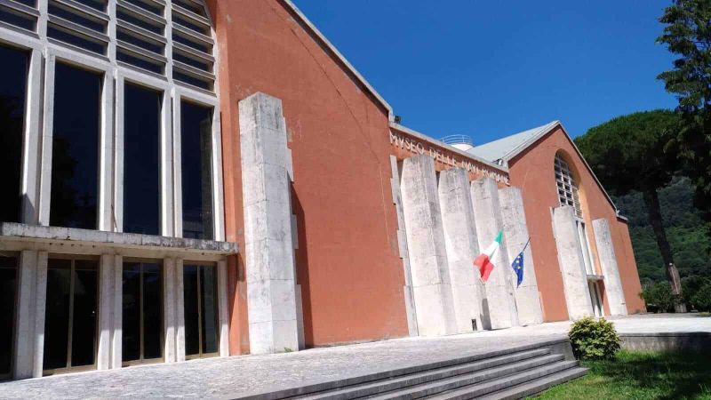 Navi di Caligola nel lago di Nemi, storia 7 Museo della Nave Romana a Nincsa, edificio moderno con facciata in mattoni rossi e grandi finestre frontali, situato tra le colline verdi, sedi delle esposizioni archeologiche e storiche sull’antica nave romana.