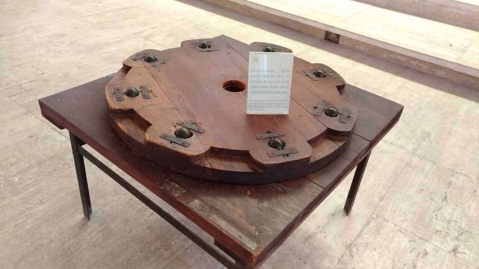 Antico tavolo in legno con accessori metallici, esposizione museale di arte e storia tradizionale, pezzo originale restaurato, display di oggetti storici in legno, esposizione culturale italiana per appunti sul blog.