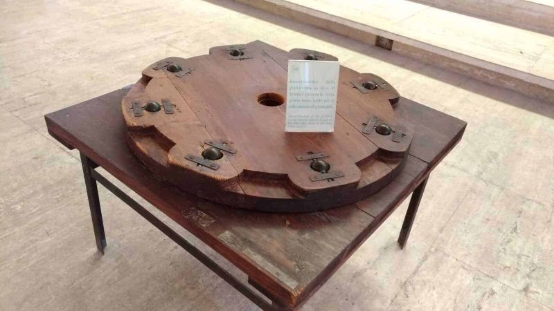 Navi di Caligola nel lago di Nemi, storia 3 Antico tavolo in legno con accessori metallici, esposizione museale di arte e storia tradizionale, pezzo originale restaurato, display di oggetti storici in legno, esposizione culturale italiana per appunti sul blog.