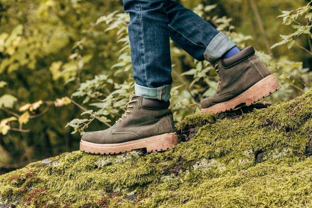 Attività da fare in autunno: Scarpe da trekking su un sentiero ricoperto di muschio in natura, apprezzando l'outdoor e l'avventura all'aria aperta con calzature resistenti e comode.